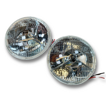 Load image into Gallery viewer, 7” Tripod P700 Head lamp units. 1 Pair  ‘Halogen PL’ Shield motif includes Halogen and side lamp bulbs. CL0603 £65.00 Pair
